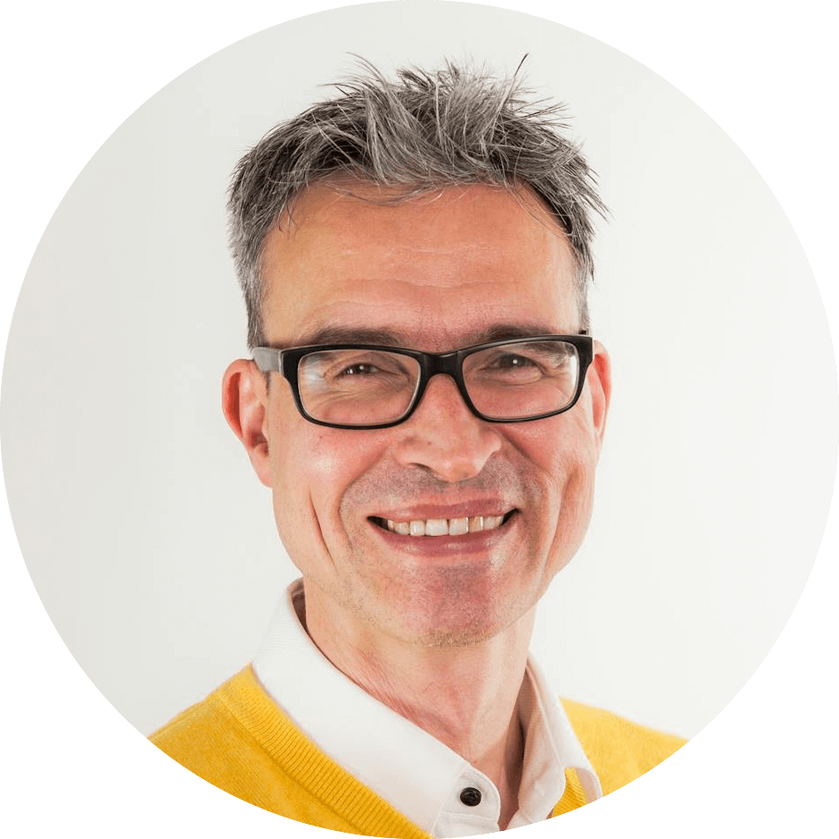 a man wearing glasses and a yellow sweater