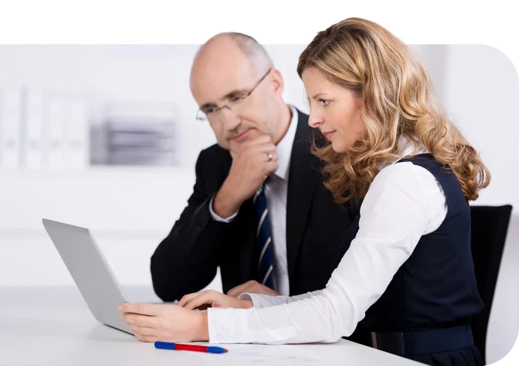 a man and woman looking at a laptop