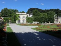 a large white building with a garden and a driveway