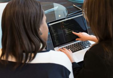 a woman pointing at a laptop screen