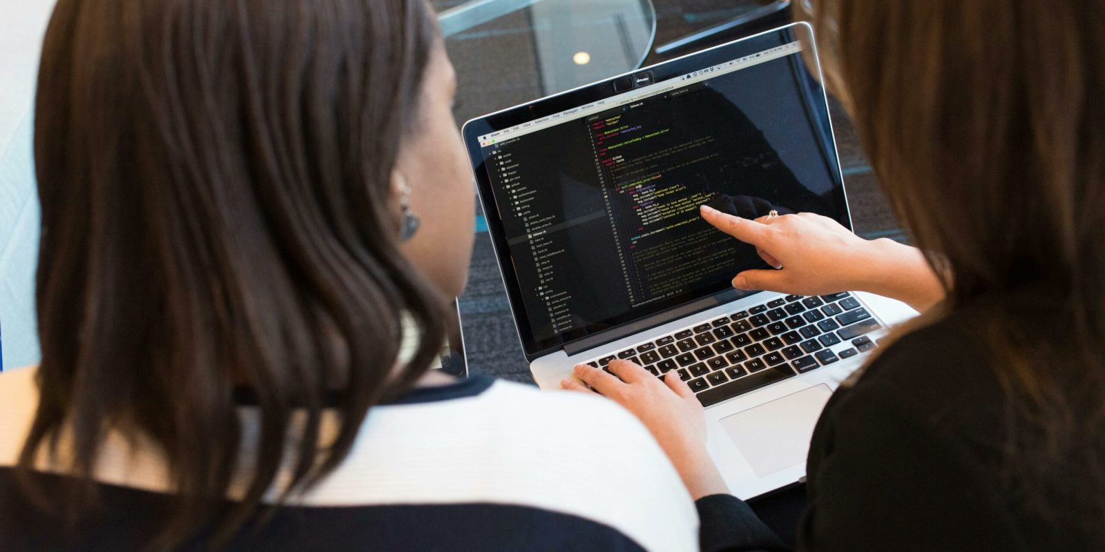 a woman pointing at a laptop screen