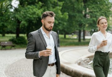 a man in a suit holding a coffee cup