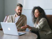 a man and woman looking at a laptop
