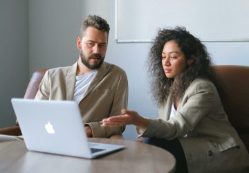 a man and woman looking at a laptop