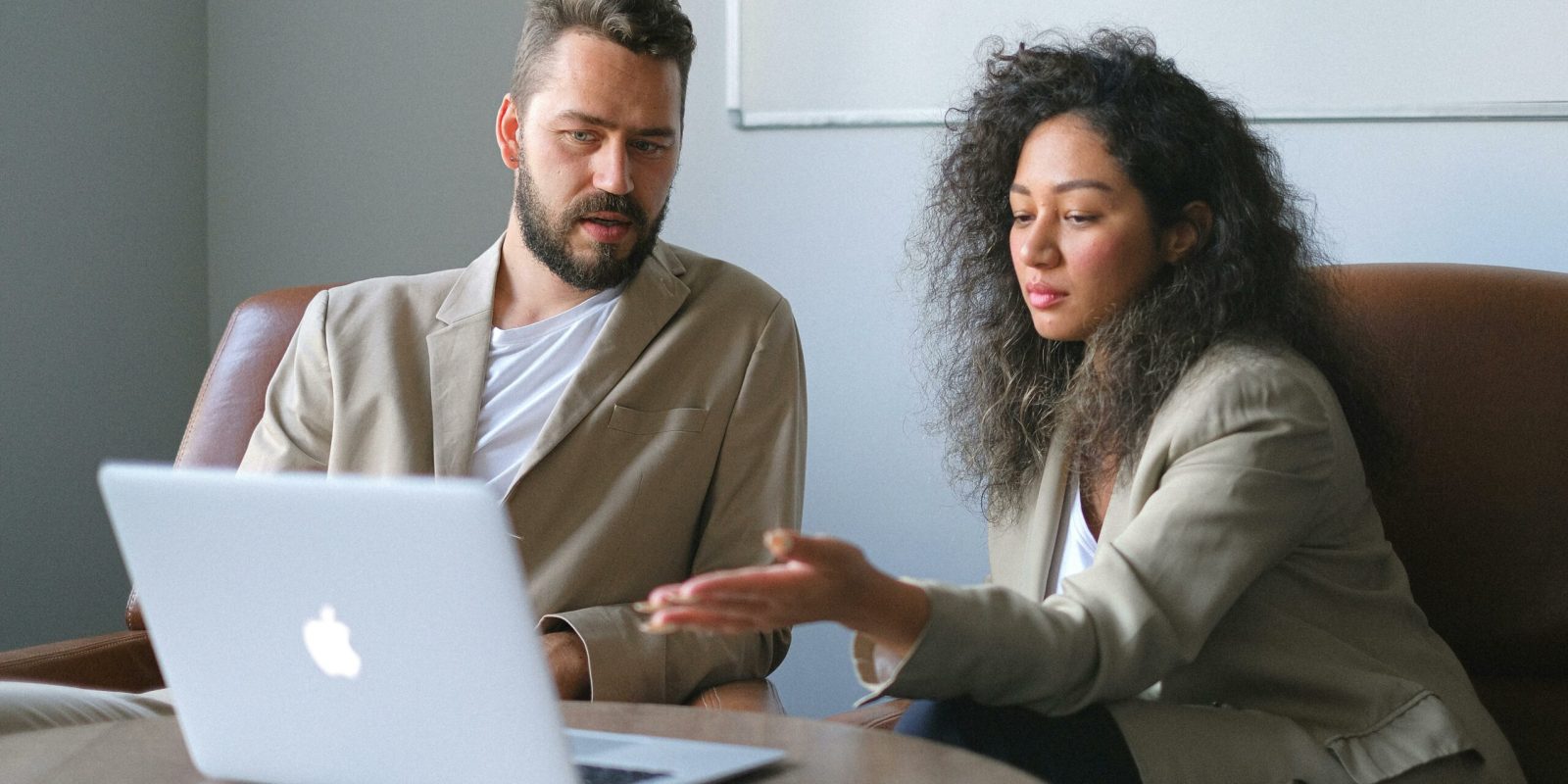 a man and woman looking at a laptop