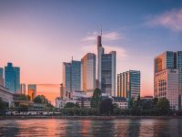 a city skyline with trees and water