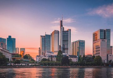 a city skyline with trees and water