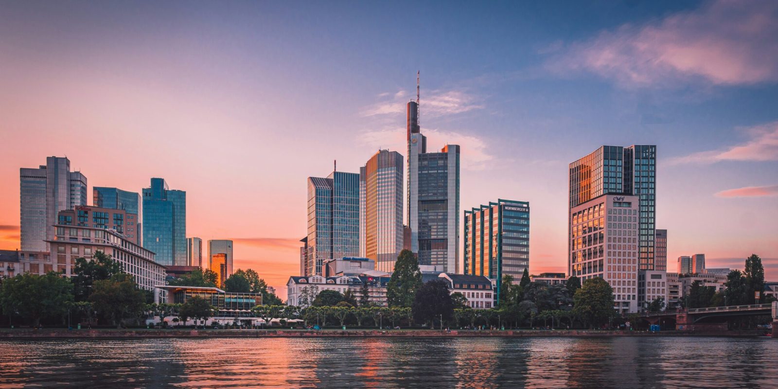 a city skyline with trees and water