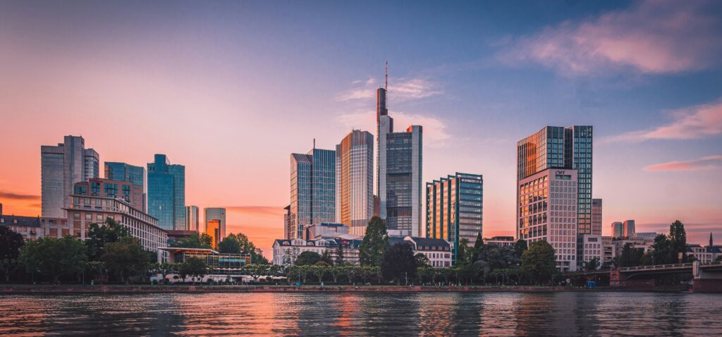 a city skyline with trees and water